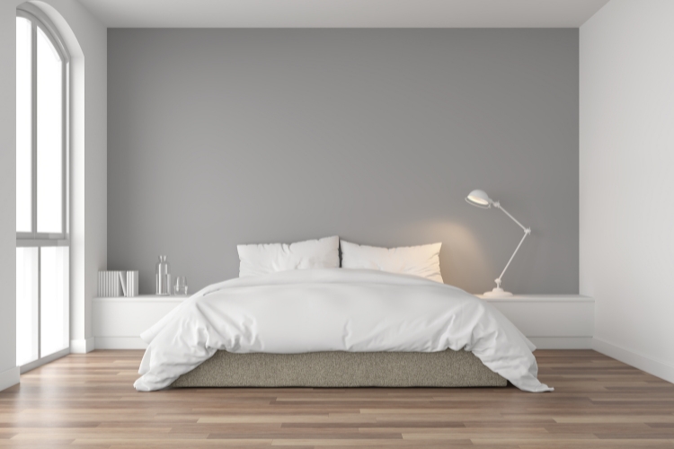 Minimalista hálószoba világos szürke falfestéssel, egyenletes matt felülettel, amely elegáns, neutrális atmoszférát nyújt és kiváló fényvisszaveréssel tágítja a teret.